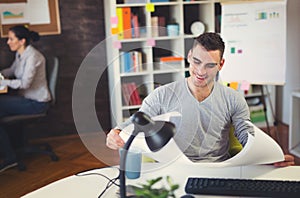 Handsome Caucasian man at work desk facing flat screen computer