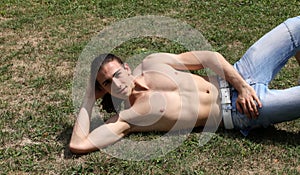 Handsome caucasian man is working out in the nature.  Gymnastics, healthy lifestyle concept.
