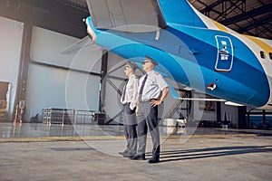 Handsome Caucasian men in pilots hats looking to the side in the outdoors in the sunny day