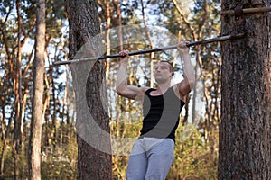 Handsome caucasian men pull-up outdoor workout cross training morning Pumping up arm exercising sports ground nature forest