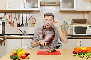 Handsome caucasian young man, sitting at table. Healthy lifestyle. Cooking at home. Prepare food.