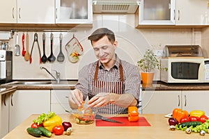 Handsome caucasian young man, sitting at table. Healthy lifestyle. Cooking at home. Prepare food.