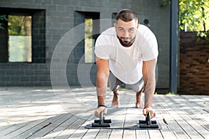 Handsome charismatic man with a fit physique doing push-ups