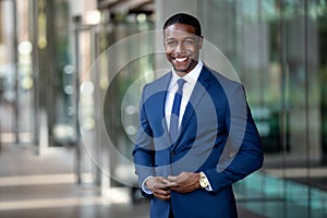 Handsome charming cheerful african american businessman in swanky modern stylish suit and tie, colorful, classy, office building