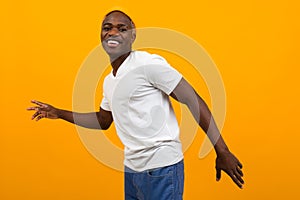 Handsome charming sexy african man dancing on yellow studio isolated background