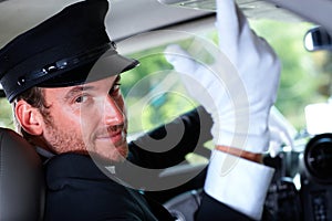 Handsome chauffeur in elegant car