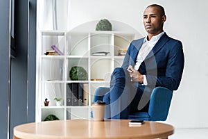 Handsome cheerful african american executive business man at the workspace office.