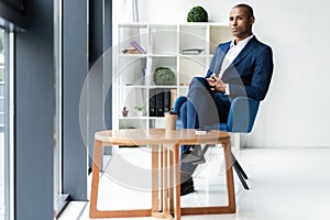 Handsome cheerful african american executive business man at the workspace office.