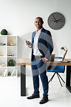 Handsome cheerful african american executive business man at the workspace office.