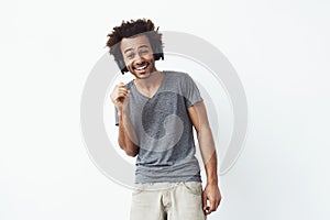 Handsome cheerful african man in headphones laughing. Isolated on white background.