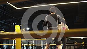 Handsome coach teaching fit girl in sport club. Sport woman boxing at gym