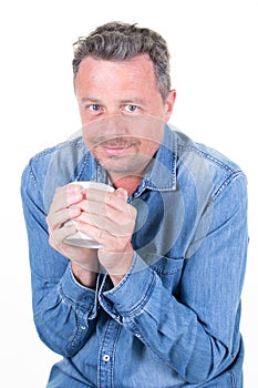 Handsome cold man refrigerated holding cup of coffee isolated over white background