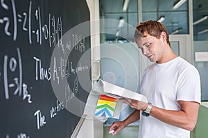 Handsome college student solving a math problem