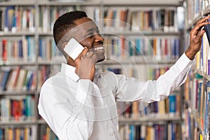 Handsome College Student Using Mobile Phone In Library