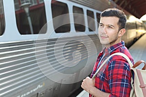 Handsome commuter smiling while waiting for his train