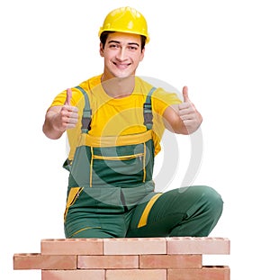 The handsome construction worker building brick wall