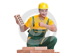 The handsome construction worker building brick wall