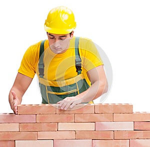 The handsome construction worker building brick wall