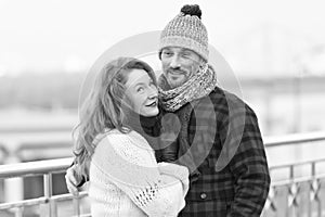 Handsome couple likes walking in winter city. Women cuddles to boyfriend in flannel jacket.