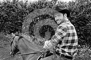 Handsome cowboy, horse rider on saddle, horseback adn boots