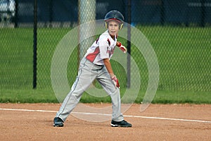 Handsome cute Young boy playing baseball waiting and protecting the base.