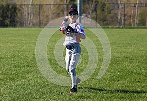 Handsome cute Young boy playing baseball waiting and protecting the base.