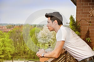 Handsome dark haired young man looking out on