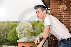 Handsome dark haired young man looking out on