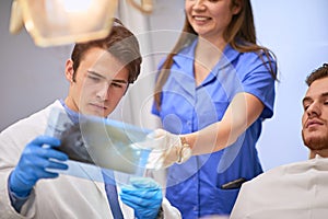 Handsome dentist examining x-ray footage of his patient