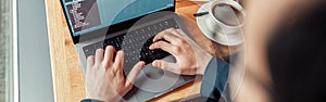 Back view of developer programmer freelancer working on project in cafe. Blurred background