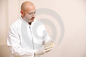 Handsome doctor plastic surgeon holds silicone breast implants. Plastic surgery concept