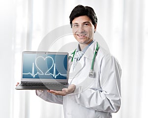 Handsome Doctor showing laptop with heartbeat