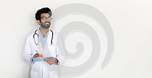 Handsome eastern doctor general practitioner taking notes, copy space