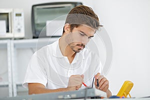 handsome electrician testing induction hobs