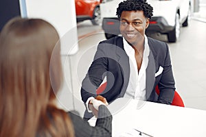 Handsome and elegant black man in a car salon