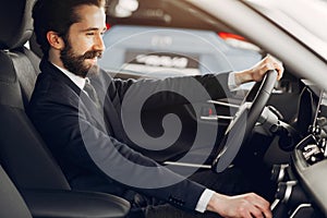 Handsome and elegant man in a car salon