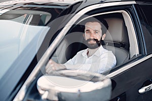 Handsome and elegant man in a car salon