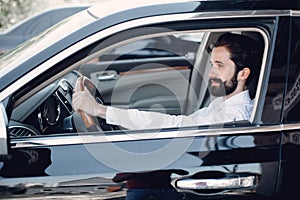 Handsome and elegant man in a car salon