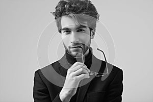 Handsome elegant man with curly hair wearing suit and glasses