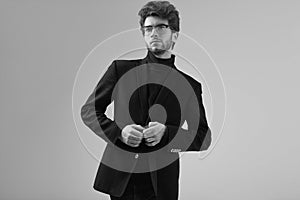 Handsome elegant man with curly hair wearing suit and glasses