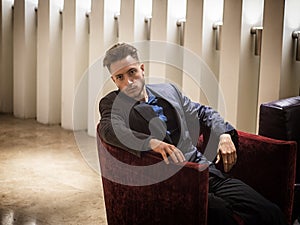 Handsome elegant man sitting in hotel lounge