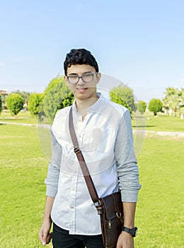 Handsome elegant young man with small bag.