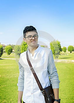 Handsome elegant young man with small bag,outdoor.