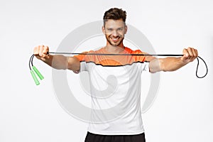 Handsome energized fitness instructor giving jump rope, instruct how lead active and healthy lifestyle, smiling daring