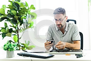 Handsome engineer repairing laptop computer.