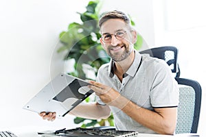 Handsome engineer repairing laptop computer.