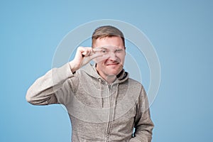 Handsome european middle aged man wearing showing something little with hands