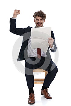 Handsome excited businessman holding the newspapaer and celebrating succes photo
