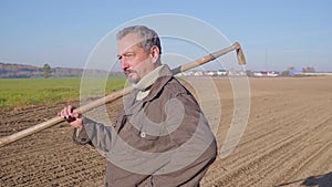 Handsome farm worker with beard with farm tools protrait