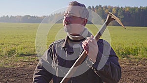 Handsome farm worker with beard with farm tools protrait